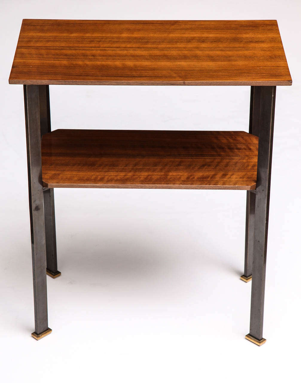 Two tiered side table in walnut with gun metal patinated legs and gilt-bronze sabots, by Leleu