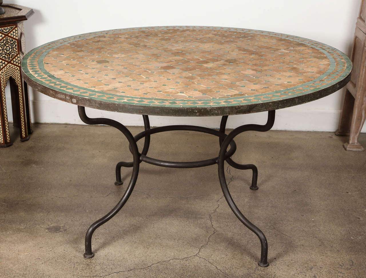 Traditional Moroccan green and tan mosaic tile table, dining height, could be used indoor or outdoor. Moroccan Mosaic table tops are hand made of a multitude of ceramic old reclaimed tiles inlaid to create complex colorful design patterns. These are
