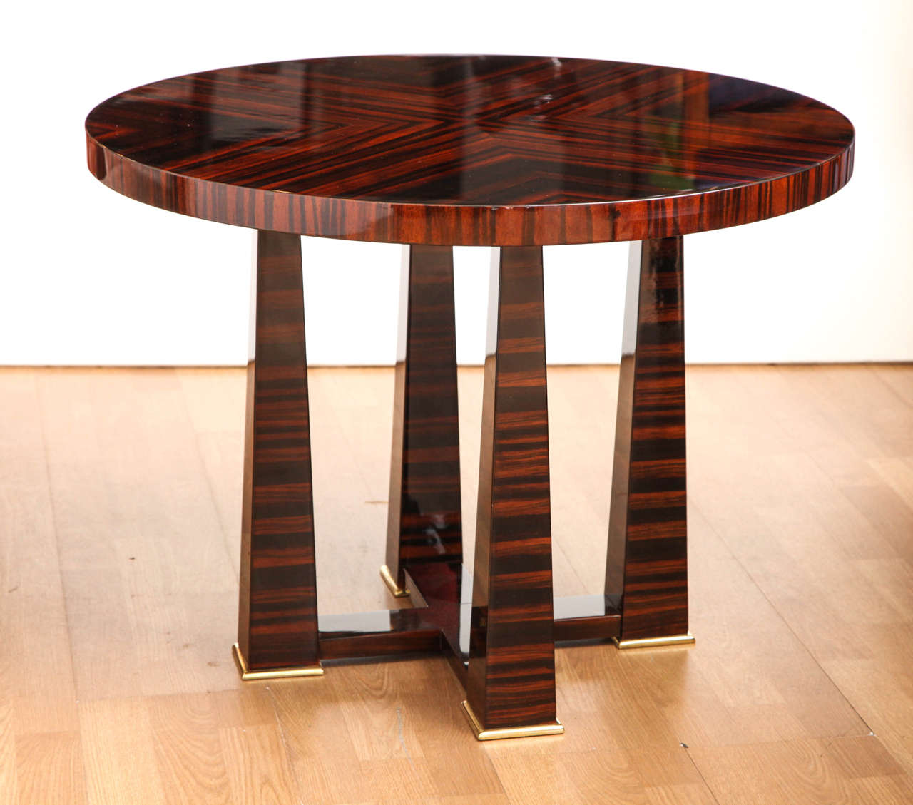 An Art Deco side table/gueridon. Bookmatched Macassar ebony with original brass sabots. 