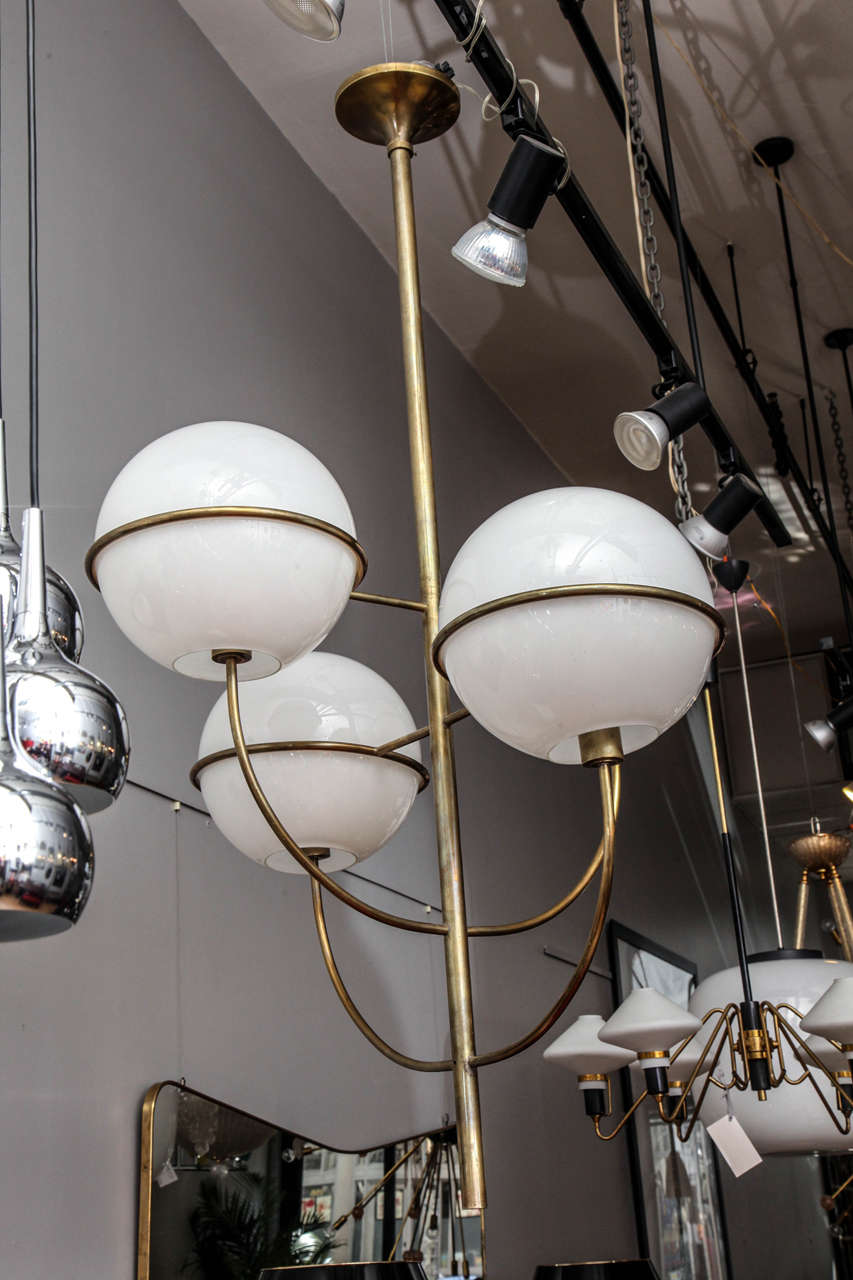 A grand scale Mid-Century Modern Gino Sarfatti. Four-globe chandelier. Brass stem. The milk glass globes are approximately 12