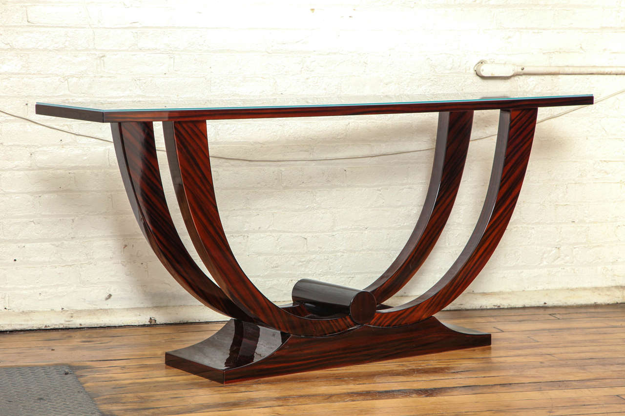 An Art Deco console table with palissandre base and etched glass top.