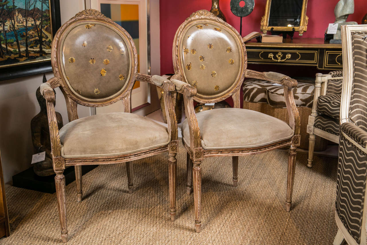 A pair of hand-carved Louis XVI style fauteuils. Made in Italy, suede and leather upholstery.