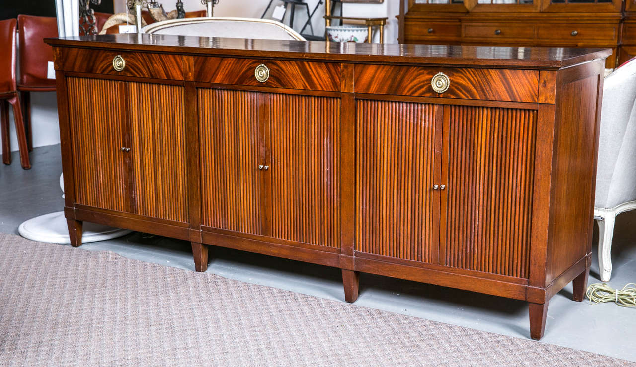 A mid century mahogany Danish credenza. Brass hardware, three bay accordion doors, and pull out shelf beneath drawers. Newly refinished.