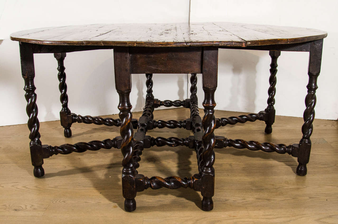 The circular chestnut board top above patinated oak 'barley-sugar twist' double gate-legs. Lovely top and finish.