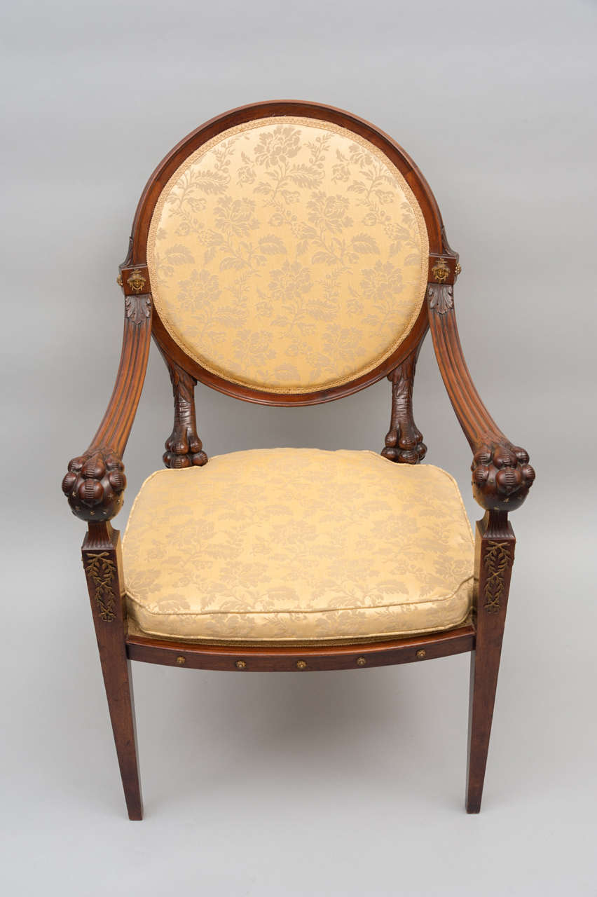 An early C19th rare and extremely stylish Russian mahogany open armchair, The circular back with carved ball and claw supports. The arms with large ball and claw terminals; on square tapering legs. With gilded brass mounts.
