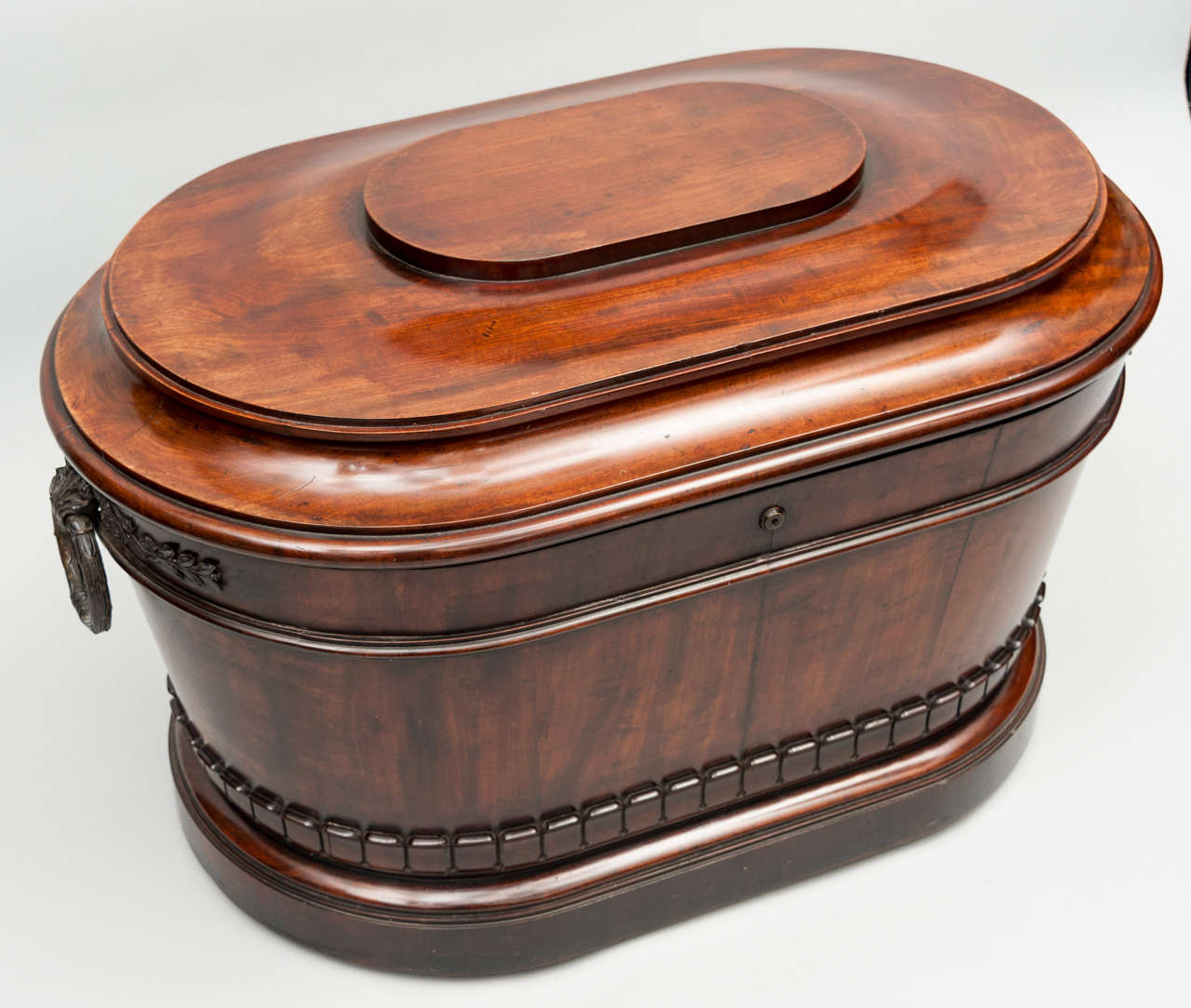 An exceptional Regency mahogany and bronze mounted oval wine cooler, of large proportions.  The shaped stepped hinged lid enclosing a good quality lift out zinc liner with carrying handles.  The main body of slightly tapered form, with fabulous