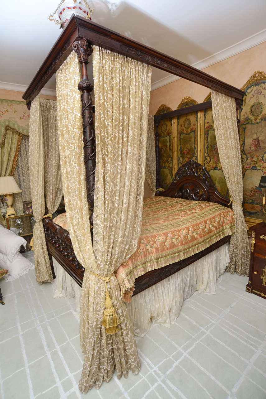 Queen size four poster bed with custom drapes and tassels. Deep carvings and piercings on headboard and footboard.  Christopher Hyland beaded fabric in a pale apricot sheer. British colonial classic design. ( We would consider selling bed without
