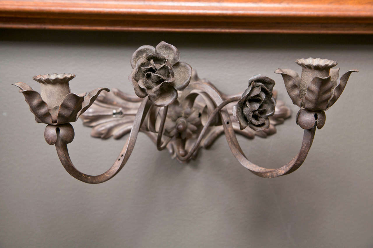 Pair of vintage Italian iron sconces, c. 1930-40 with two arms and stylized flower and leaf decoration.