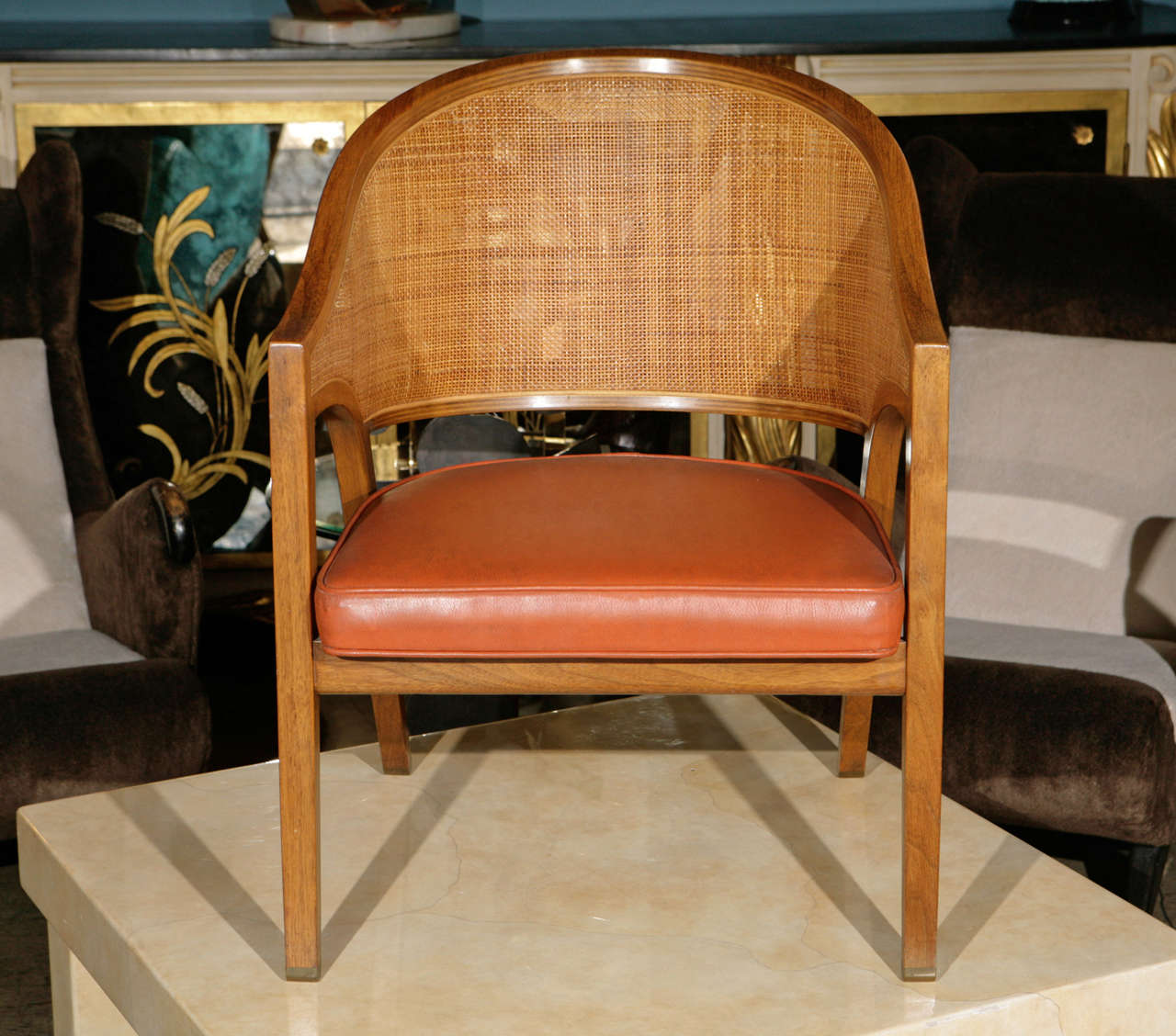 Single mid century armchair by Edward Wormley for Dunbar. Has a finely caned back seat and brass feet.  Seat is in orange leather.