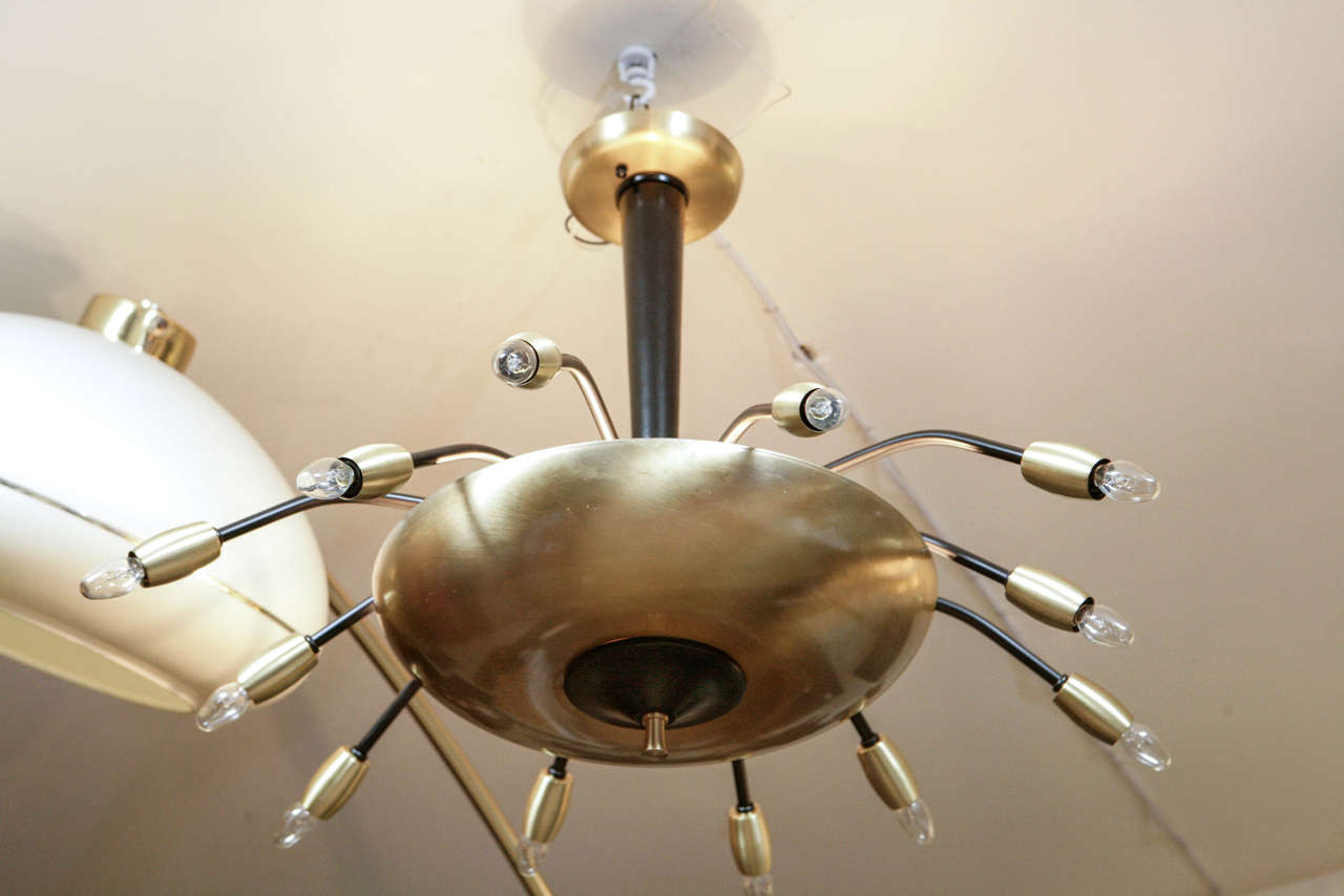 A Modernist twelve-light satin brass and black enameled chandelier.