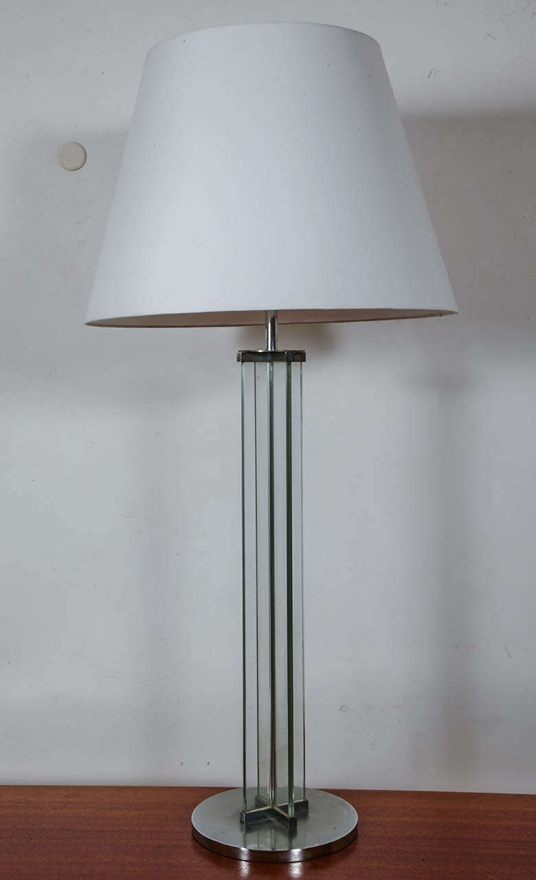 High glass and chromed steel table lamp by Jacques Adnet, 1930.
Crossed glass shaft on a circular base; Triple lightning with vasque.
Base diameter 25 cm / 10 inches;
