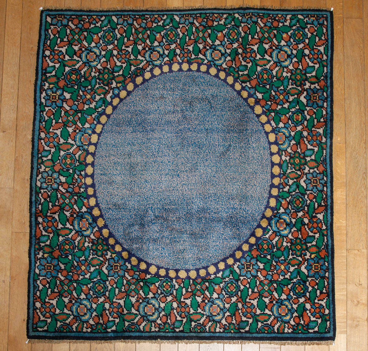 A rectangular Art Deco rug by Kunstwerkstede De Coene, workshop located in Kortrijk (Courtrai), Belgium. Floral border with a central blue medallion.