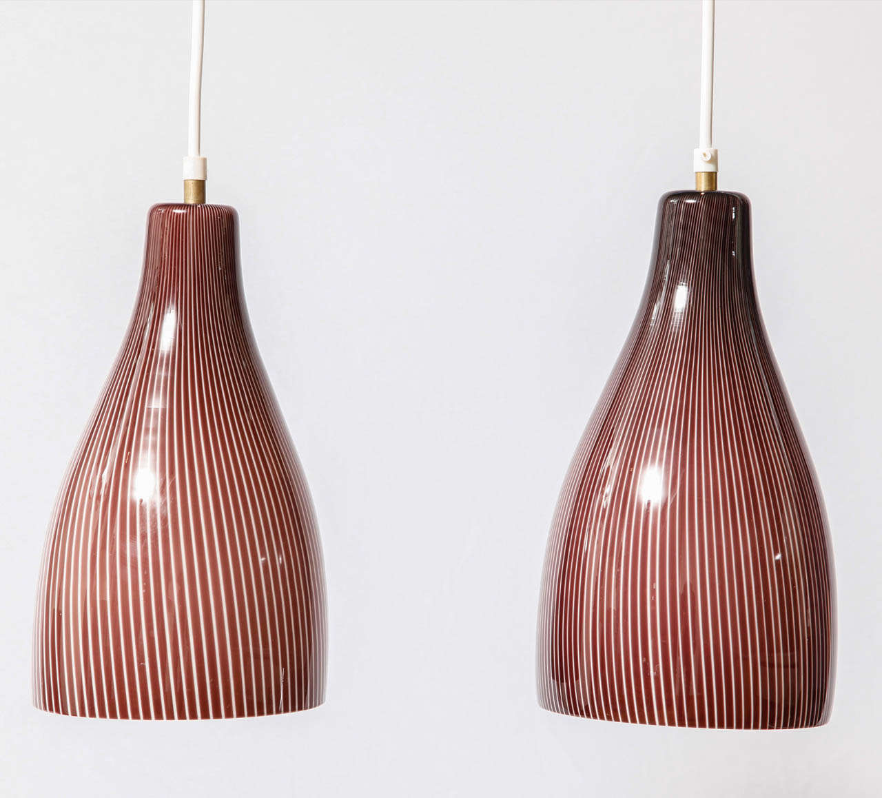 Rare set of four Tessuto pendant designed by Massimo Vignelli (1931-2014) and executed by Venini, glassworks in Murano, Italy.
Venini period label on one 'shade' (see image 6).
Lightly twisted white and purple stripes on an inner white opaque glass.