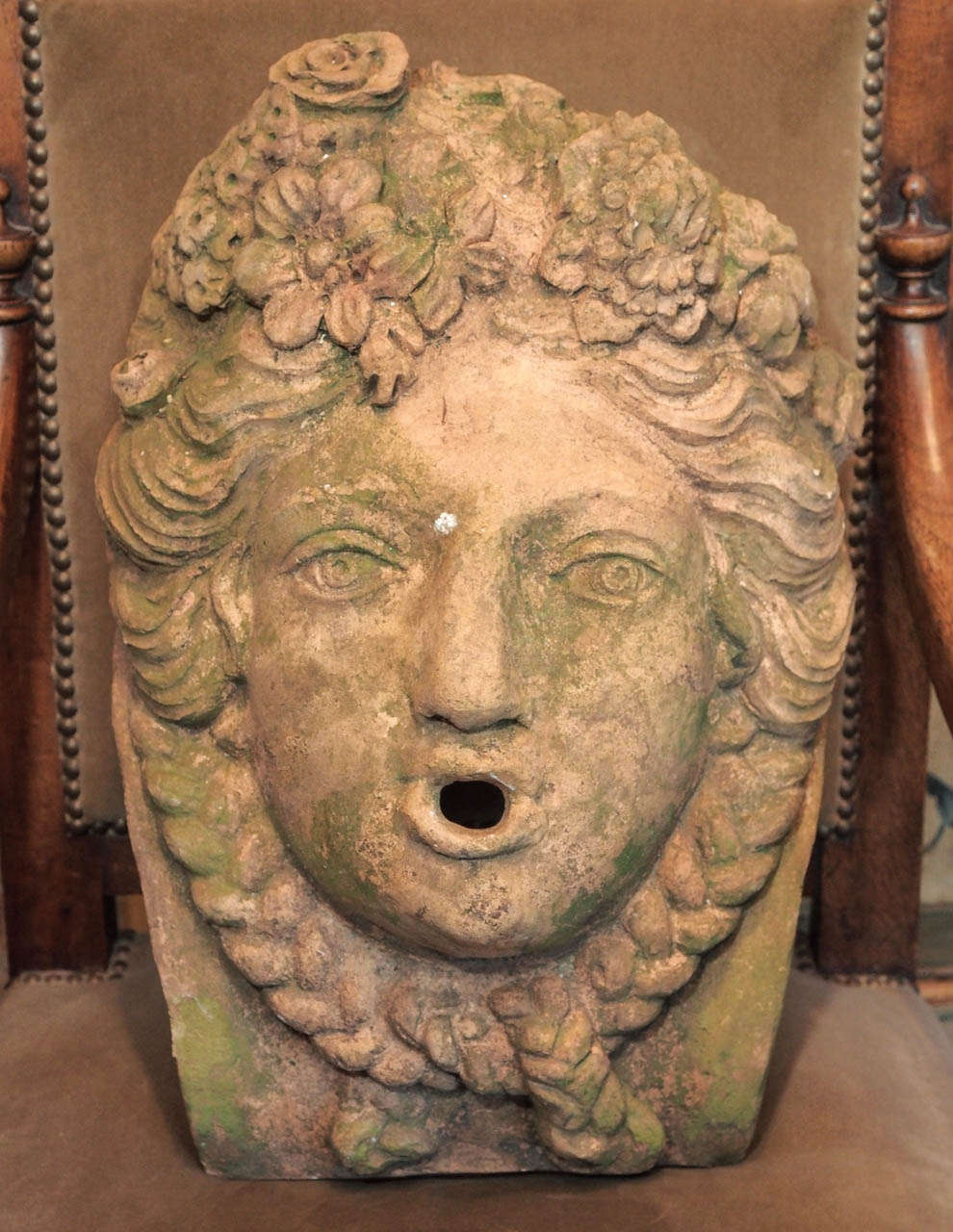 French terra cotta fountain mask of a classical maiden with braided hair and a mass of flowers in her hair.  Nicely patinated.