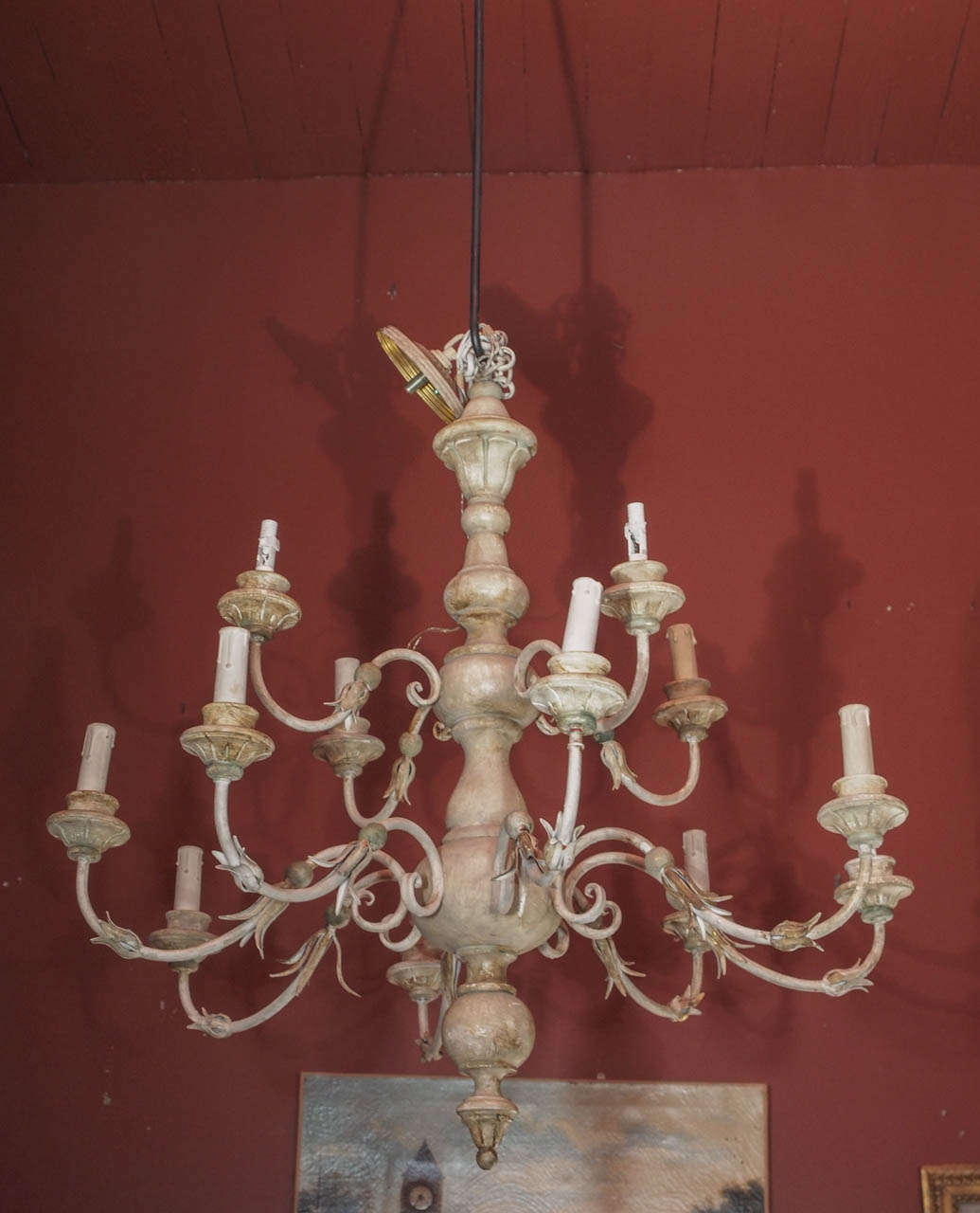 Double tiered painted wood and iron chandelier.  A wooden ball and small thin leaves adorn the 12 scrolled iron arms.  Chandelier is not yet wired for US use.
Cost of wiring will be added to stated price.