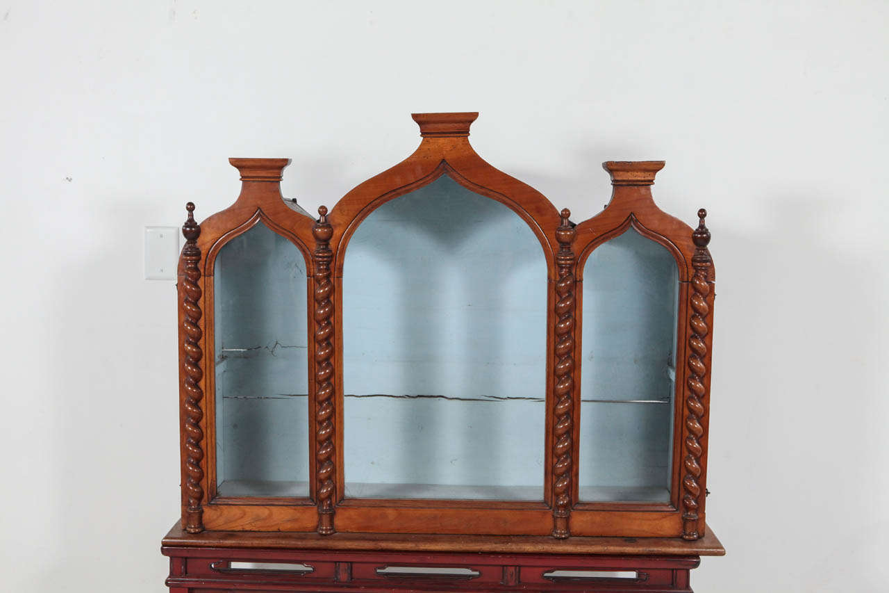 Fruitwood wall hanging cabinet with glass panels.