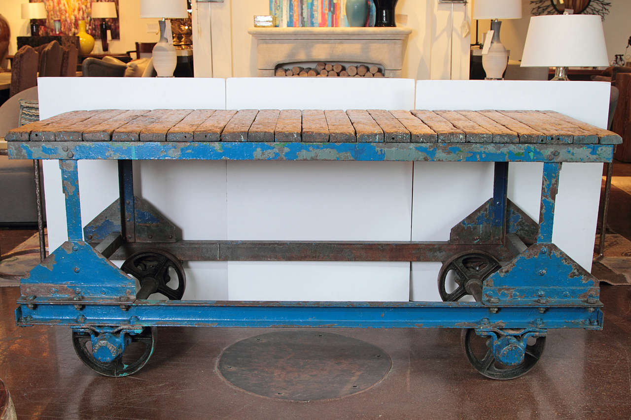 Industrial Factory Cart as Console Table, circa 1940's

Made of wax distressed slats of pine top that has been wax and repurposed for smooth shine and splinter-free. 
Moveable cart with original cast iron wheels. 
Cast iron base of original