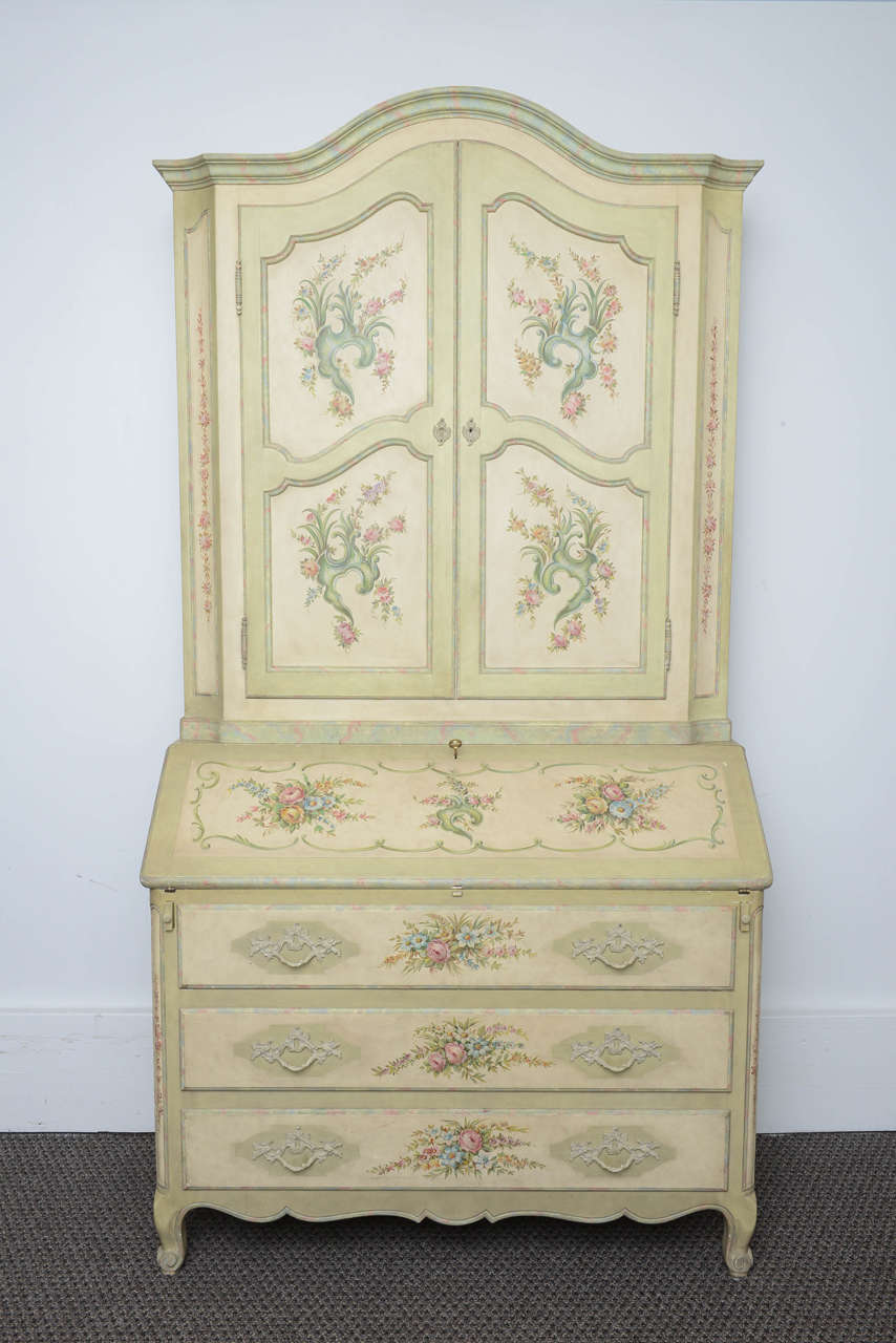 This is a very nice hand-painted bureau or secretary bookcase in the Louis XV style, it was made in Italy.
To the front it has a drop flap for writing with two pull-out supports, above there are two doors to the top, all hand-painted with many