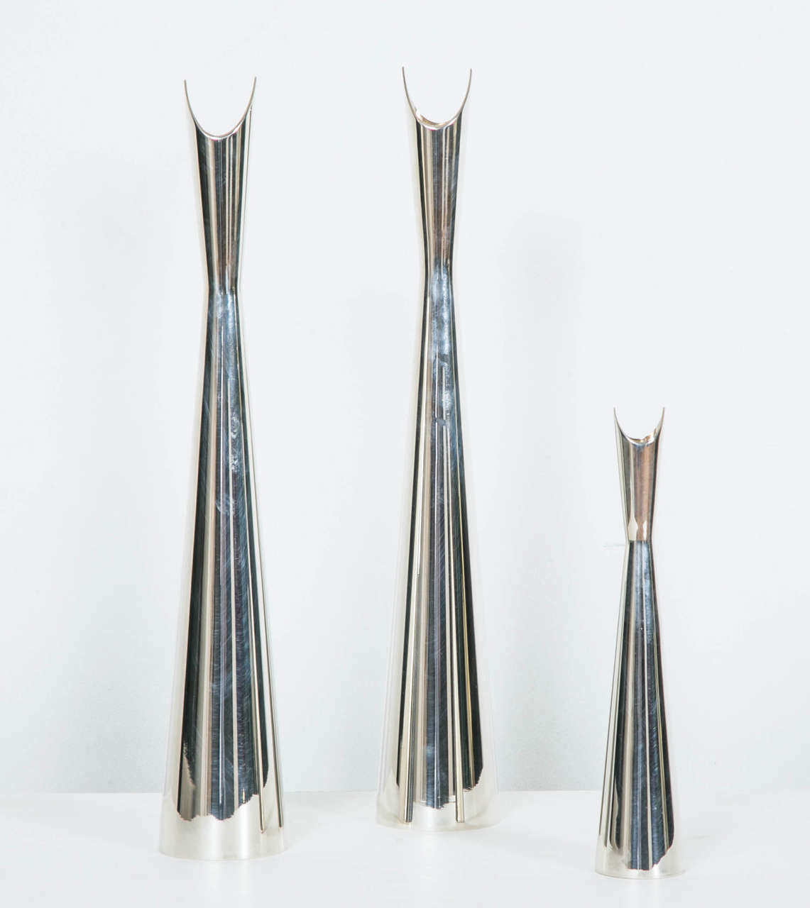 Set of three “Cardinal” silvered metal vases, by Lino Sabattini for Maison Christofle, 1970.
Signed Christofle France.
Measures: Higher 35 x D 6 cm, lower 21 x D 4 cm.

Lino Sabattini (1925) Italian designer specialized in table ware and