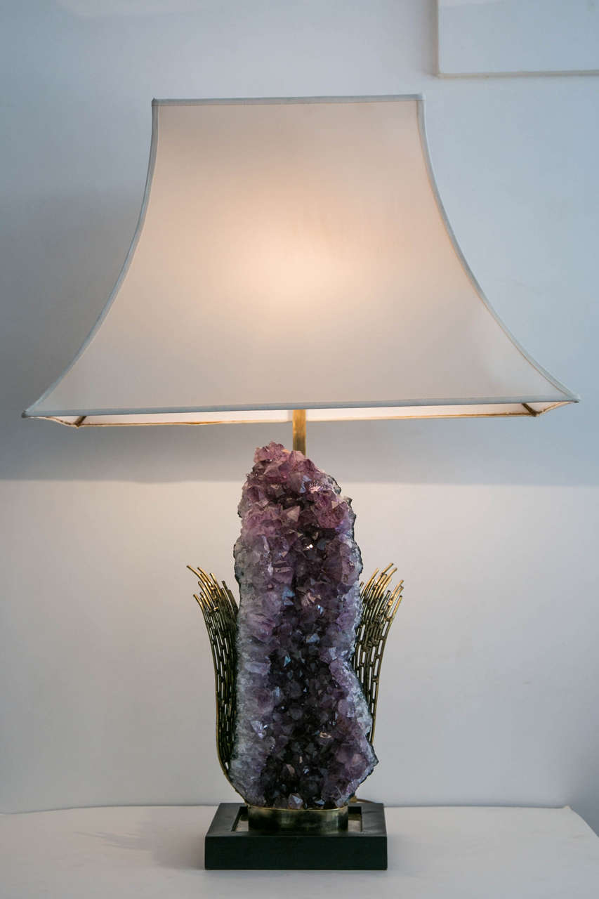 Important sculpted gilt brass table lamp with a high amethyst geode, by Jacques Duval-Brasseur, 1970s.
Square blackened wood base and fabric lampshade.
Signed.
At geode height: 66 cm.