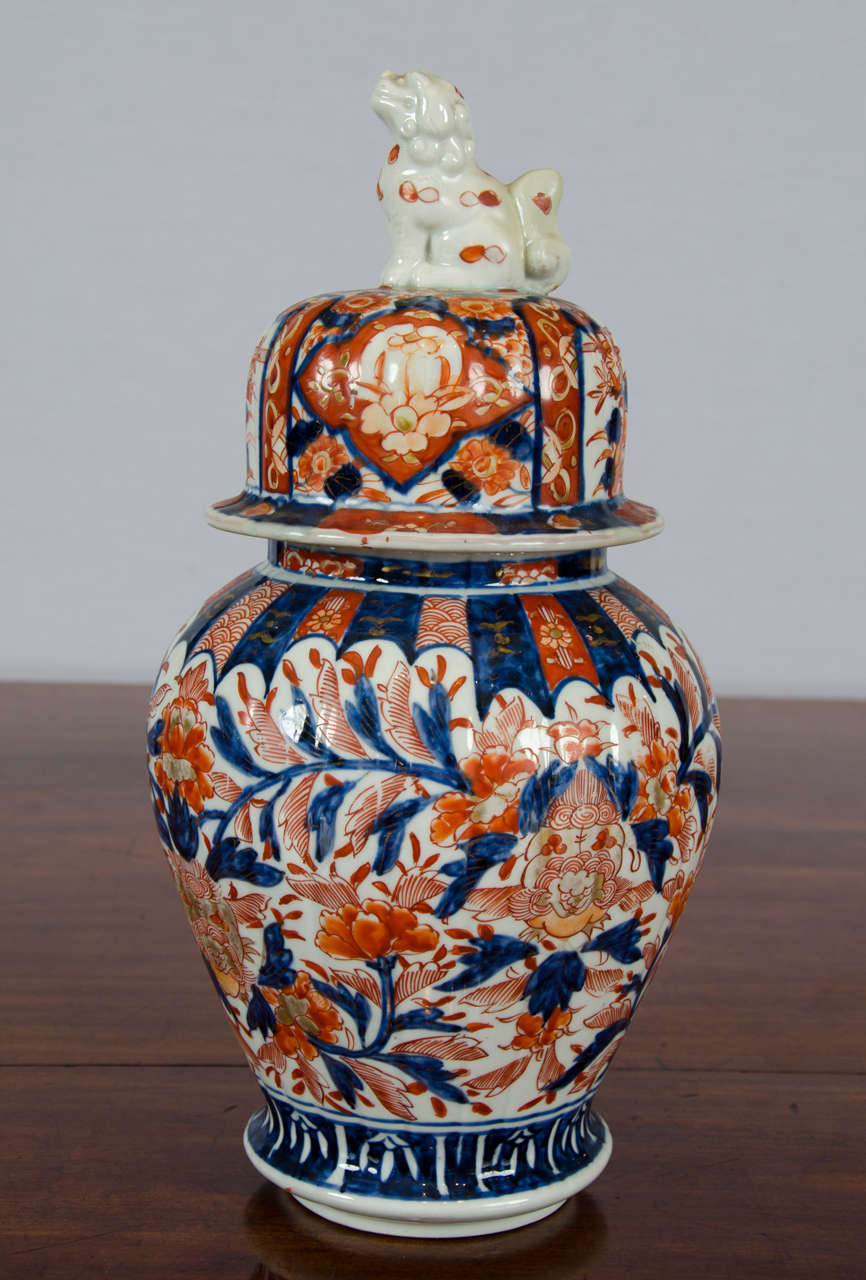 A very charming 19th century lidded Japanese Imari jar with a Foo dog figure topped finial. The jar is hand-painted in an elaborate traditional Imari floral pattern. The cover to this Imari Jar, while being of the same age and having a well fitted