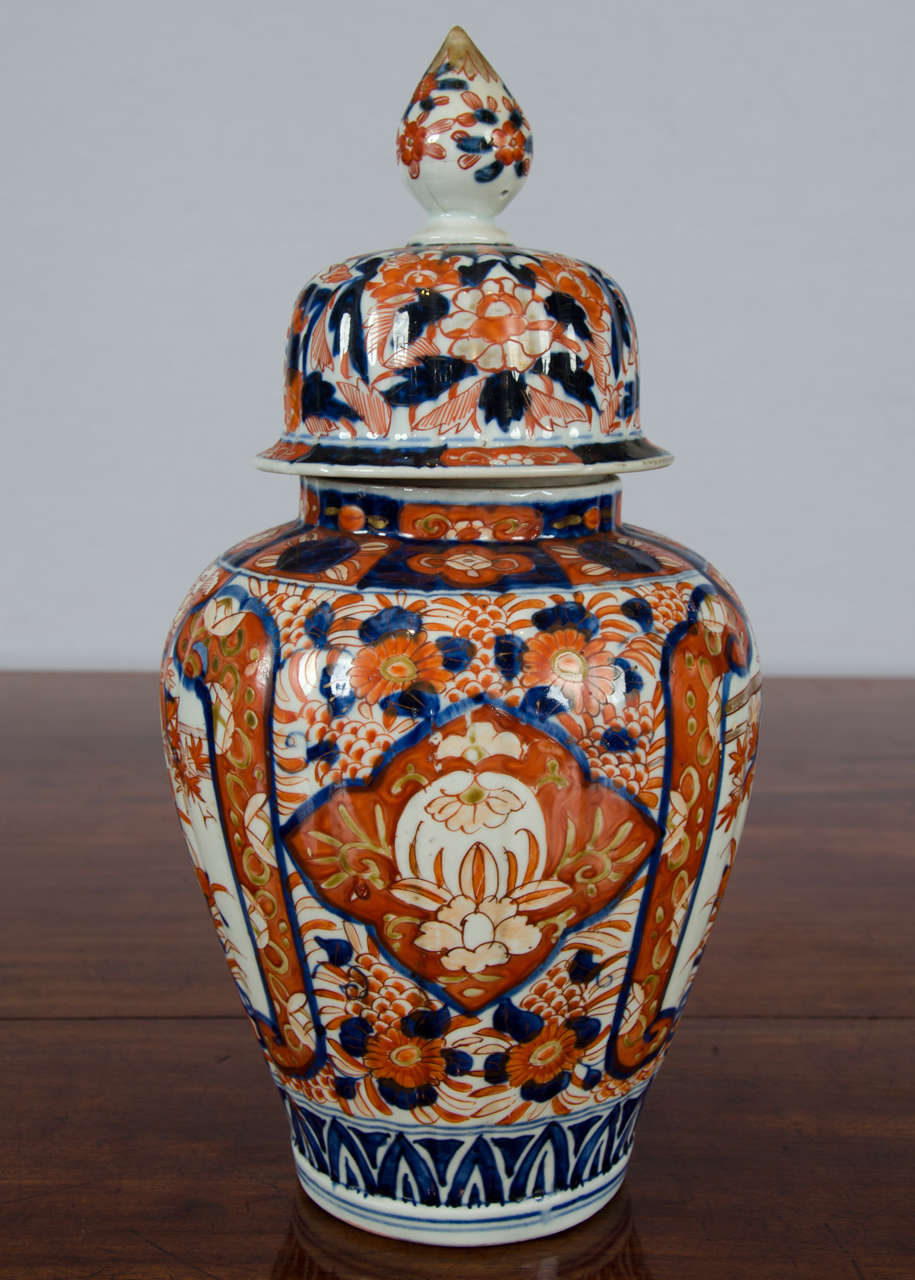 A very good looking 19th century lidded Japanese Imari jar with a flame shaped topped finial. The jar is hand-painted in an elaborate traditional Imari floral pattern and has a very faint vertical ribbed indentation pattern on the body and lid. It