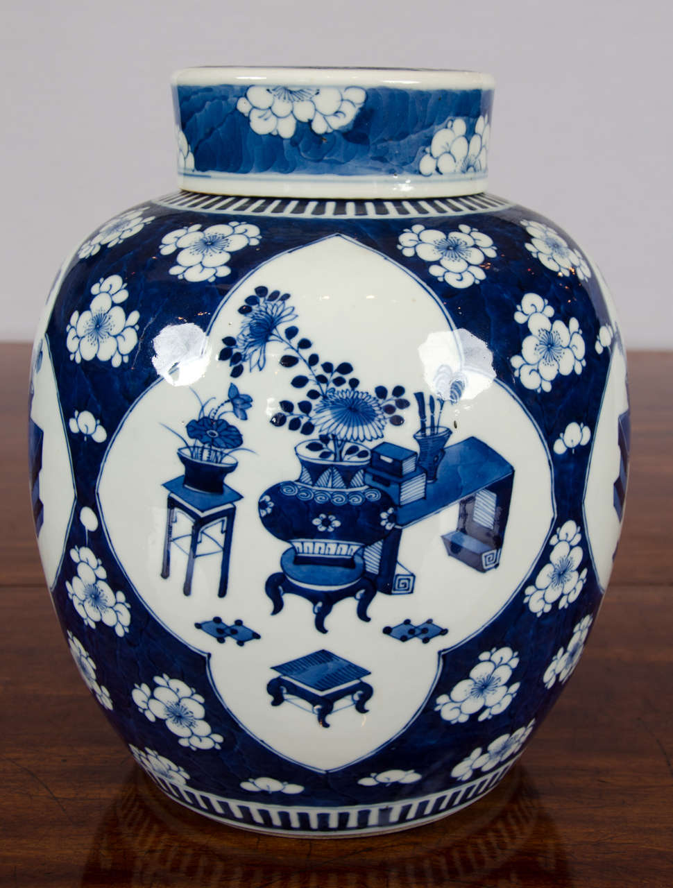 A highly decorative Chinese blue and white ginger jar with matching lid featuring floral and furniture designs. The jar is signed on the bottom and is in excellent condition. It measures 11 ½ in – 29.3 cm in height with a diameter of 9 ½ in – 24 cm.