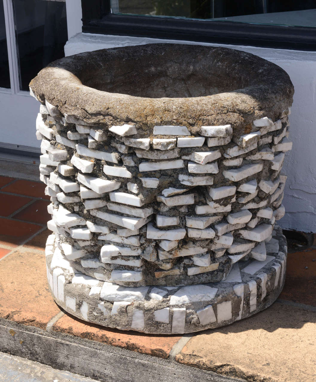 Unusual pair of cement and marble planters on bases.