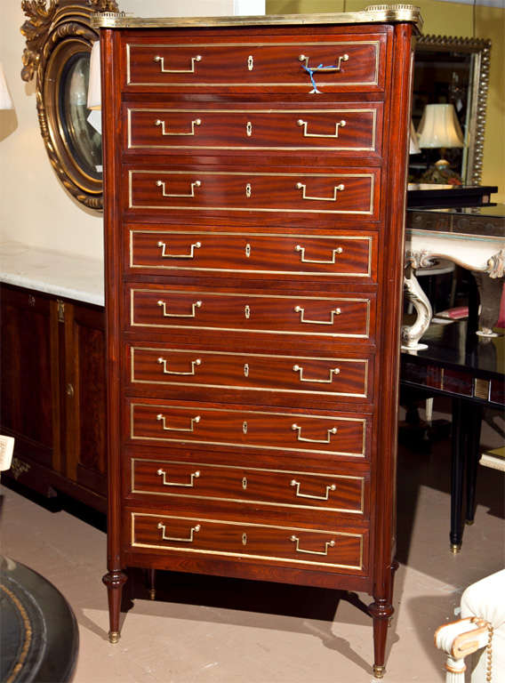 Fine quality Maison Jansen nine-drawer lingerie chest. The Louis XVI style legs have bronze capped ends supporting a set of nine bronze frame banded drawers flanked by fluted column sides. The recessed cabinet sides are also bronzed framed. There is