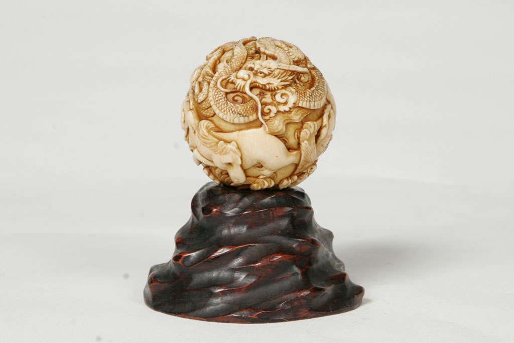 A 19th century Japanese Ivory spherical Okimono.
Depicting an intricate confusion of animals of the Chinese zodiac, including a tiger, an ox, a horse, a dragon, pug dogs, monkeys etc.
6.2cms diam. Weight 192cms.
On a carved wooden base.