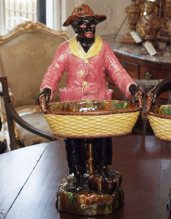 Pair (male and female) black figures carrying baskets and sitting on cotton bales.