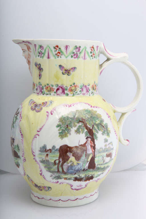 A rare First Period Worcester porcelain yellow ground mask jug decorated with three colored transfer prints of farm scenes