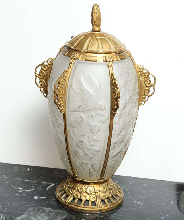 Marius Ernest Sabino.
Rare et importante lampe de table Art déco, vers 1928.
Verre dépoli moulé d'un motif de feuillage stylisé et d'oiseaux, dans une armature de bronze doré.
H : 20 1/2 in.