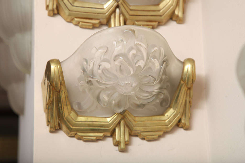 Sabino:
Clear and frosted glass wall sconces molded with a chrysanthemum motif, in a gilded bronze frame.
Signed "Sabino Paris" and numbered,
circa 1920.
A set of five sconces available, two pairs and one double-shade sconce.
