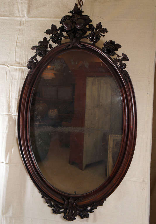 Oval Victorian mirror with walnut frame, beautifully carved with roses, grapes, and 
crab apples in  exquisite detail