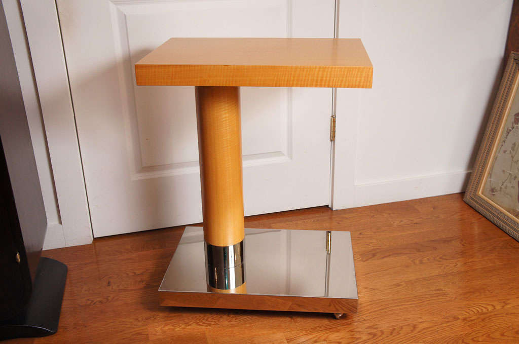 Sycamore veneer wood table top and pedestal, rests on a polished chrome rolling stand.
A quantity of two are available.