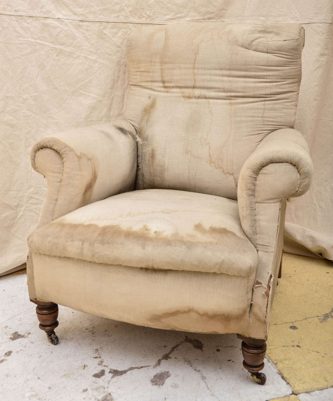 English Late 19th Cent. Howard Style Club Chair On Turned Circular Front Legs & Rear Tapered Rectangular Rear Legs With Brass Castors Having Brown Ceramic Wheels. The Upholstered Seat Has A Rounded Front Edge. The Arms Have A Out Swept Curve As Does