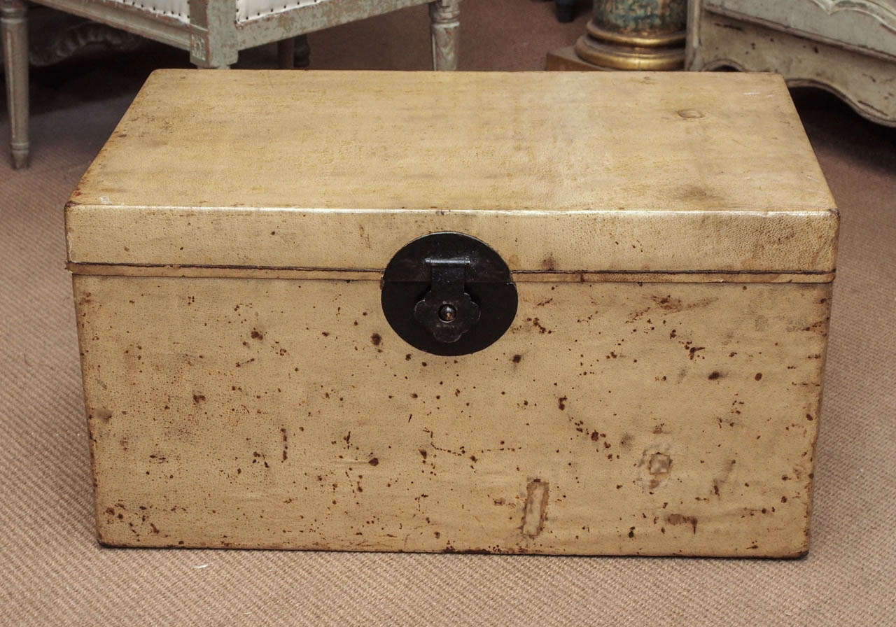 Chinese parchment trunk with red lacquered interior.