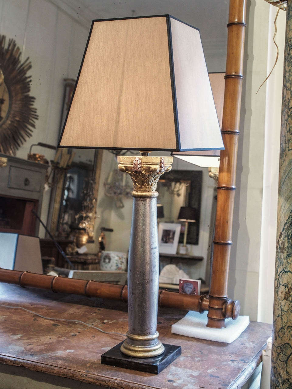 A pair of silver and gold gilt wood column lamps with shades on metal base