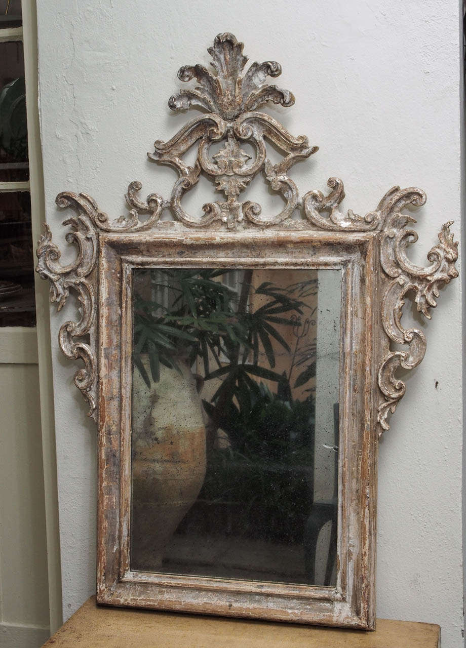 A Sicilian carved wood mirror, painted and silver leafed