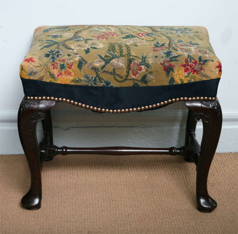 George II Irish mahogany stool with associated needlework, the shaped apron over acanthus and scroll carved legs ending in pad feet, joined by turned stretcher base.  Note: an identical stool with straight apron sold Christies - The Gothick Pavilion