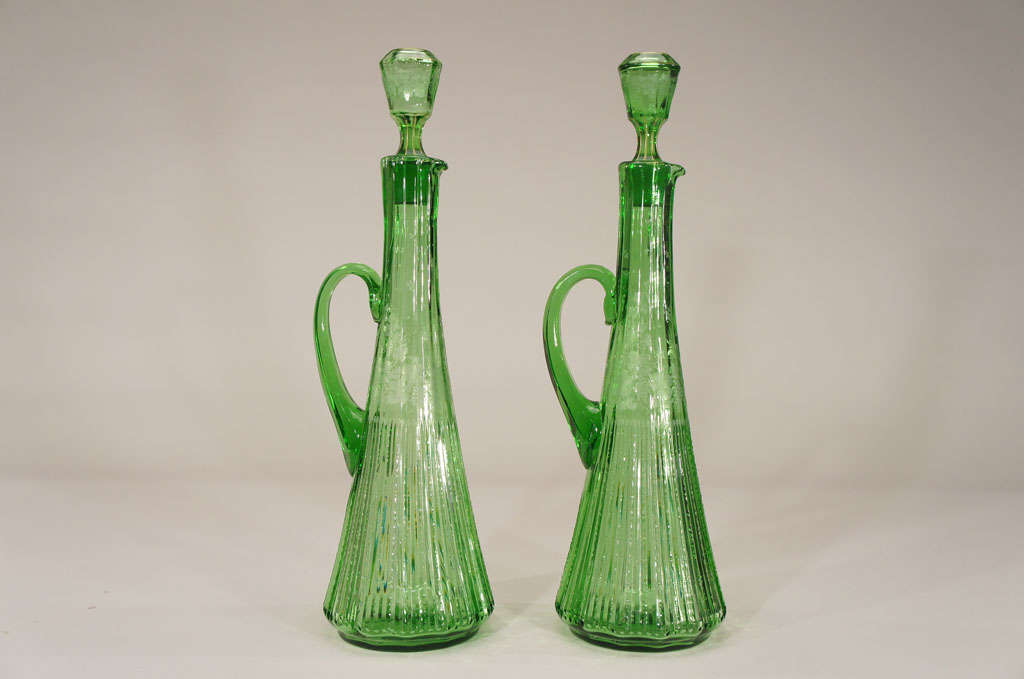 A gorgeous pair of hand blown crystal decanters with all over zipper cutting, intaglio floral cutting and applied handles. These beauties stand 22 1/2