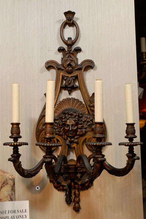 Exquisite pair of patinated bronze four light sconces. Notice the faces and incredibly detailed bronze work.