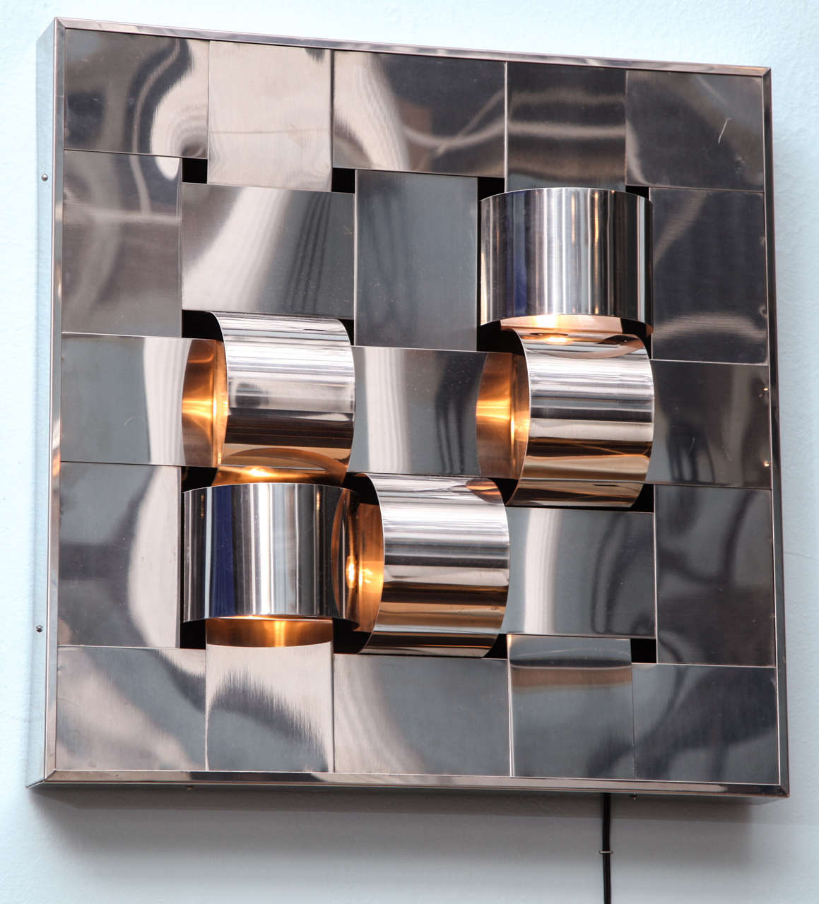 Stainless steel box form with woven strips creating flat and convex lines throughout.  5 illuminated areas that hold candelabra bulbs.