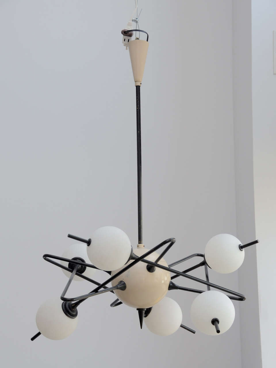 Italian Chandelier by Stilnovo. Six Metal Bent Arms Connected to a Lacquered  Metal Sphere and ending with  Hand Blown  Off-White Glass Globes