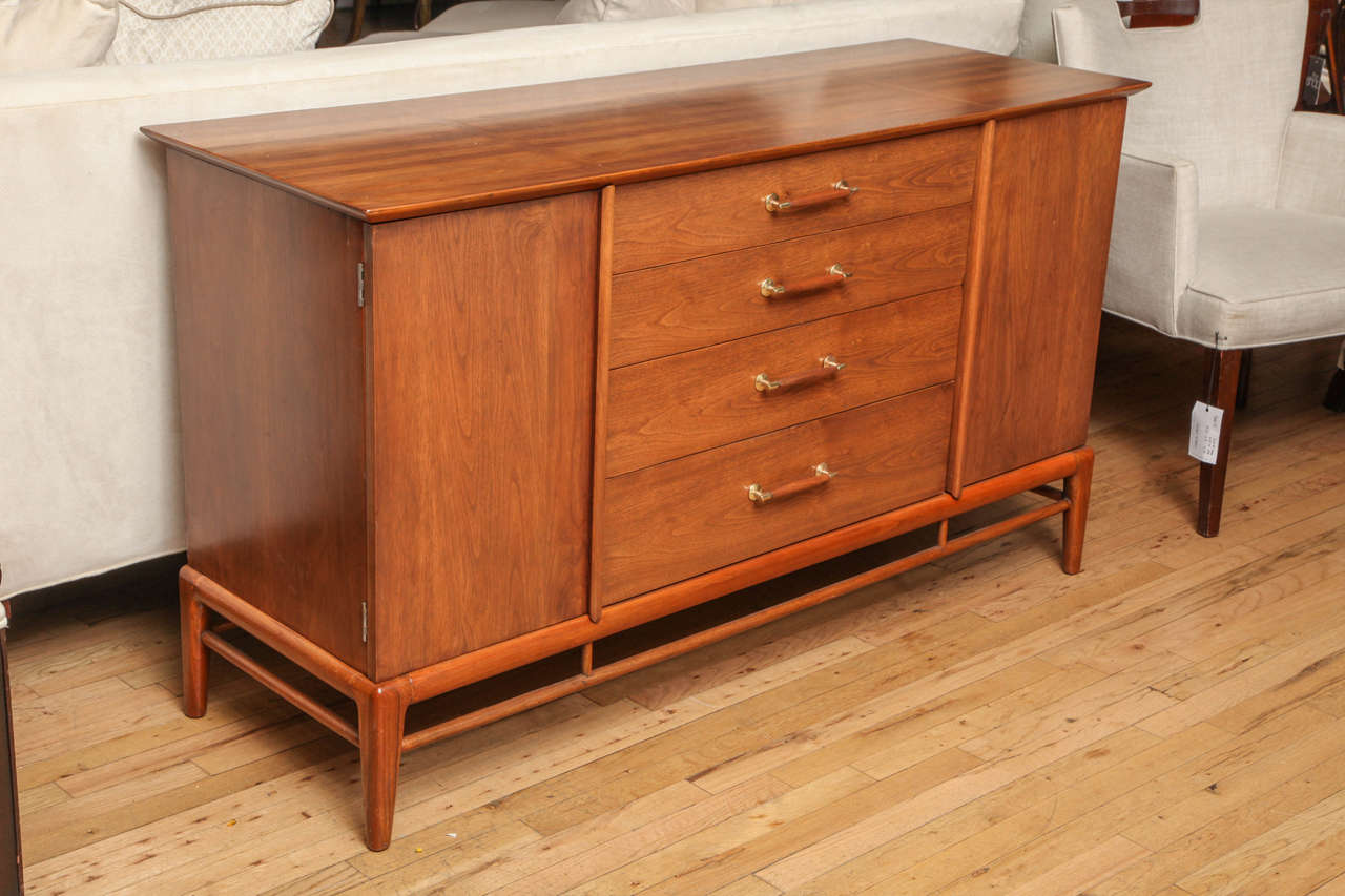 Mid-Century sideboard by Heritage Henredon with 4 center drawers and two cabinets with adjustable shelves.