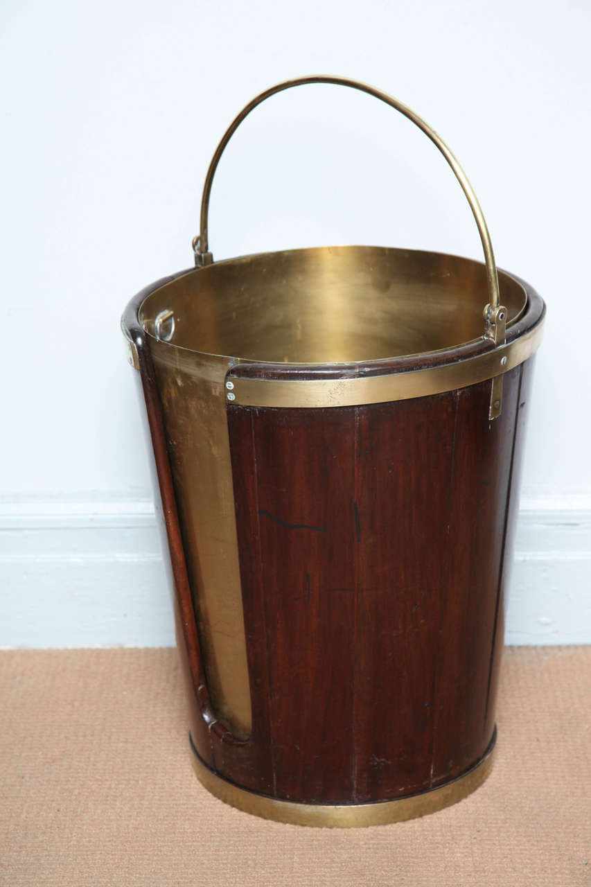 Fine George III Mahogany and brass plate bucket of impressive scale, the bail handle over tapering mahogany staved body, bound in brass and possessing a pleasing surface and patina.  Now with later brass liner (would not have been lined originally,