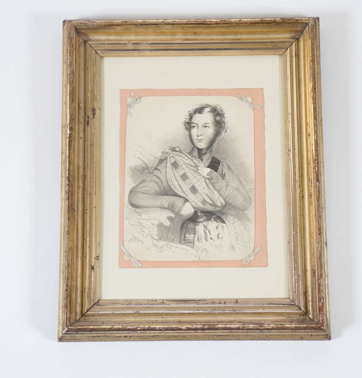 Charcoal on paper of an elegant young gentleman in Scottish tartan costume on original backing with silk ribbon tied corners conservation mounted in a period 'lemon gold' gilt frame, circa 1835. Drawing on card measures 7.25