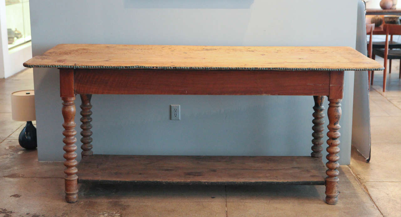 This beautiful turned leg console table has two drawers and the most fantastic oxidized upholstery nailheads along the top portion.