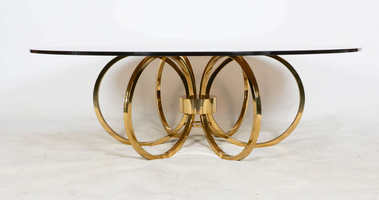 Coffee table with a bold brass base topped with beautiful bronze tinted glass. Chic! Please contact for location.